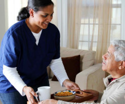 caregiver give a meal to senior man