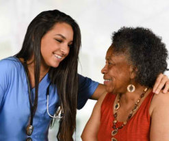 caregiver wearing stethoscopes and senior woman smiling