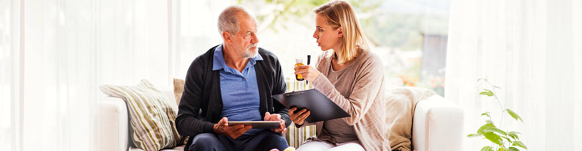 adult woman and senior man sitting on the sofa talking