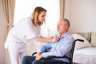 caregiver fixed the polo of senior man in the wheelchair