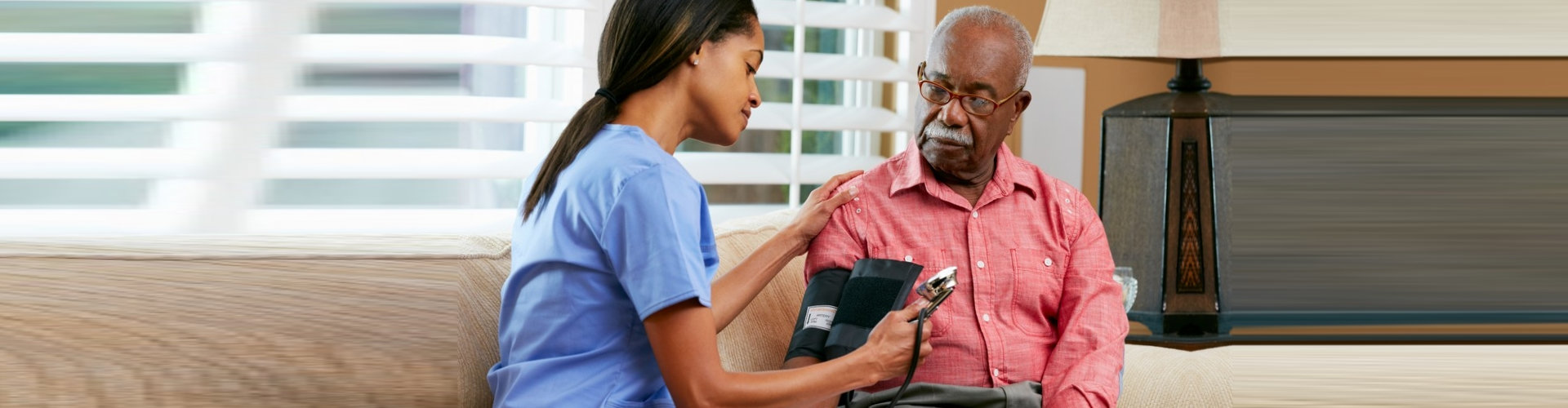 female caregiver doing blood pressure monitoring to senior man